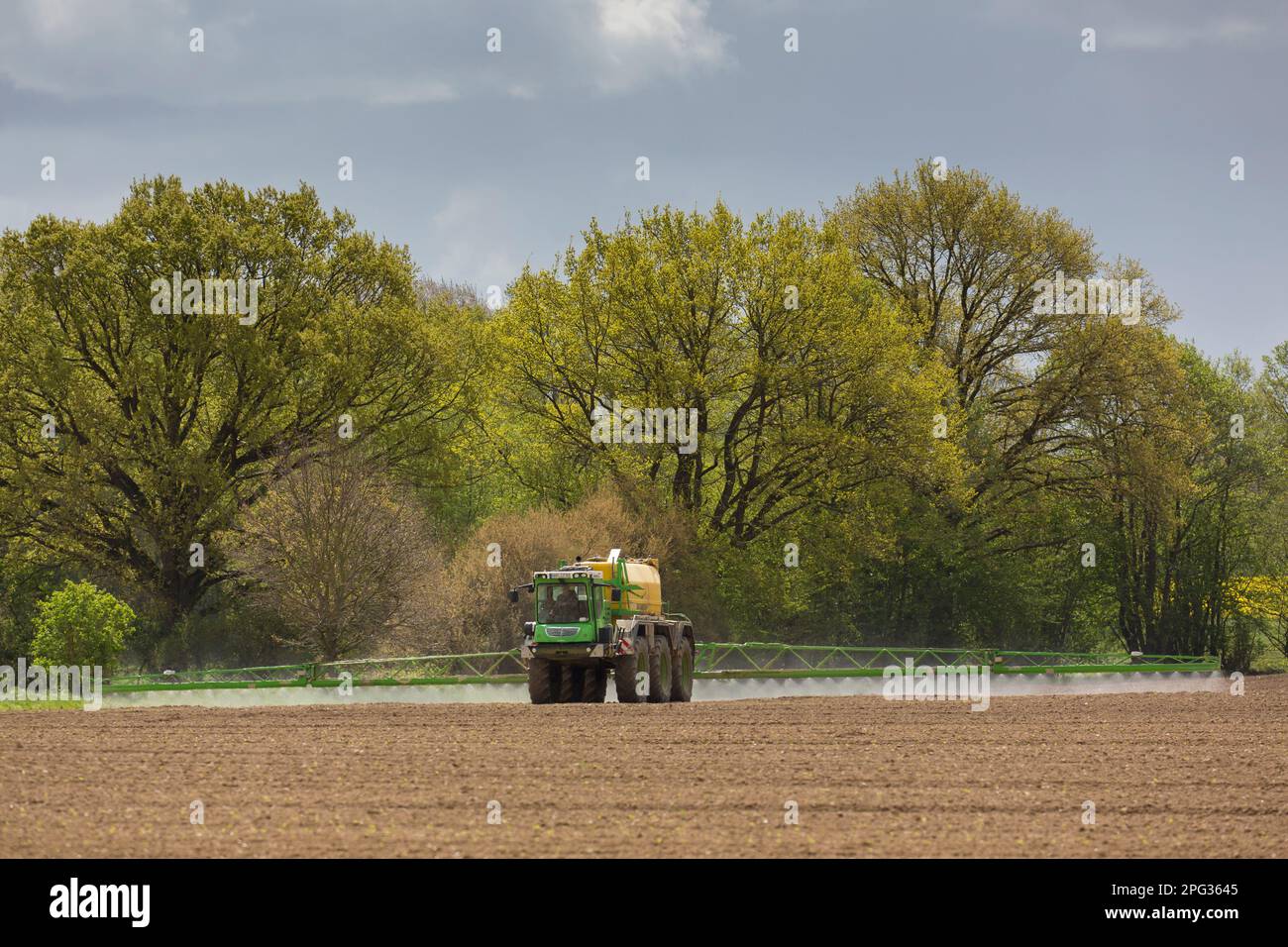 Coltivatore che spruzza un campo. Meclemburgo-Pomerania occidentale, Germania Foto Stock