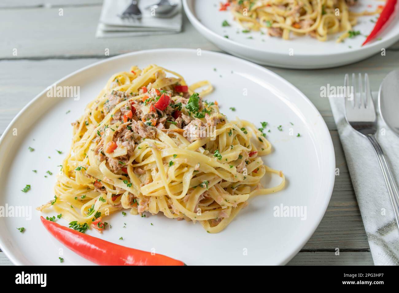 Pasta aglio e olio al tonno. Tagliatelle con olio d'oliva, aglio, prezzemolo e peperoncino. Cucina italiana Foto Stock
