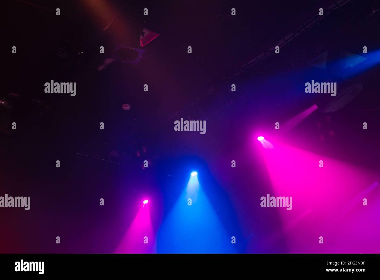 Luci panoramiche viola e blu in fumo su sfondo scuro, illuminazione moderna palco Foto Stock