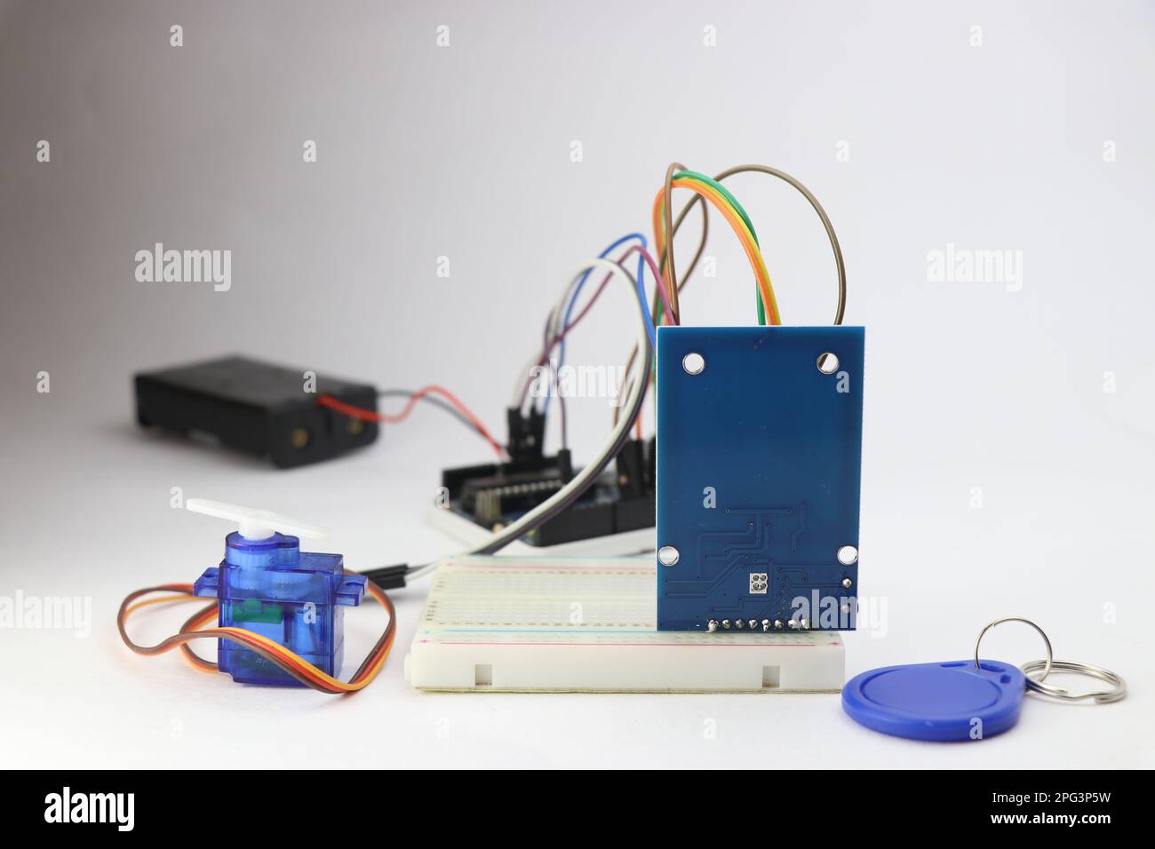 Modulo RFID con tag, micro servo e altri componenti elettronici collegati a una breadboard. Progetti elettronici con cavi e breadboard Foto Stock
