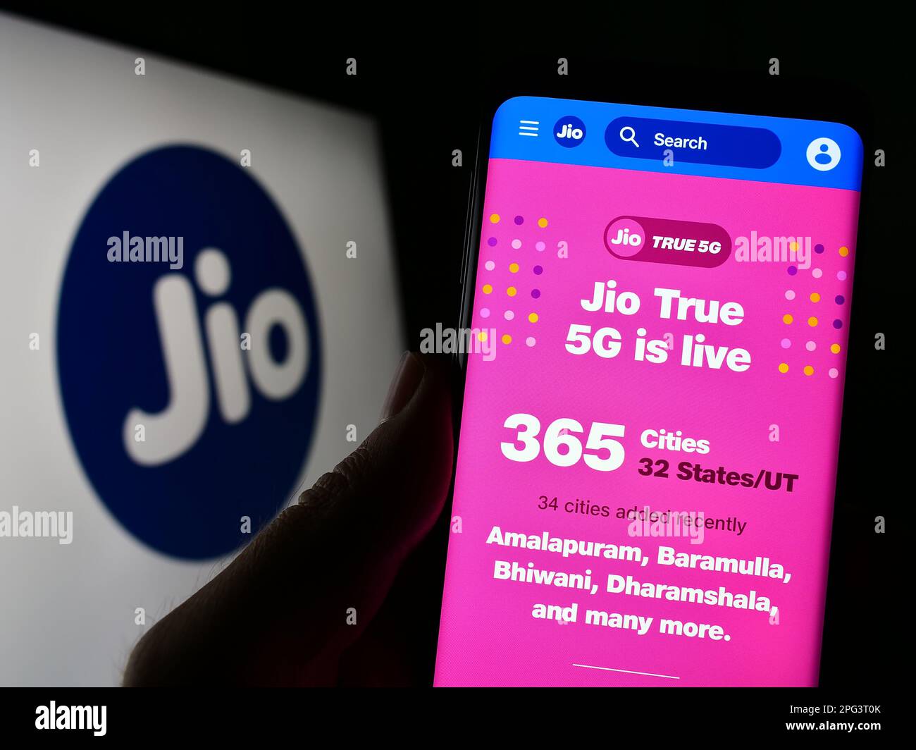 Persona in possesso di smartphone con pagina web della società indiana di telecomunicazioni Reliance Jio sullo schermo con logo. Messa a fuoco al centro del display del telefono. Foto Stock