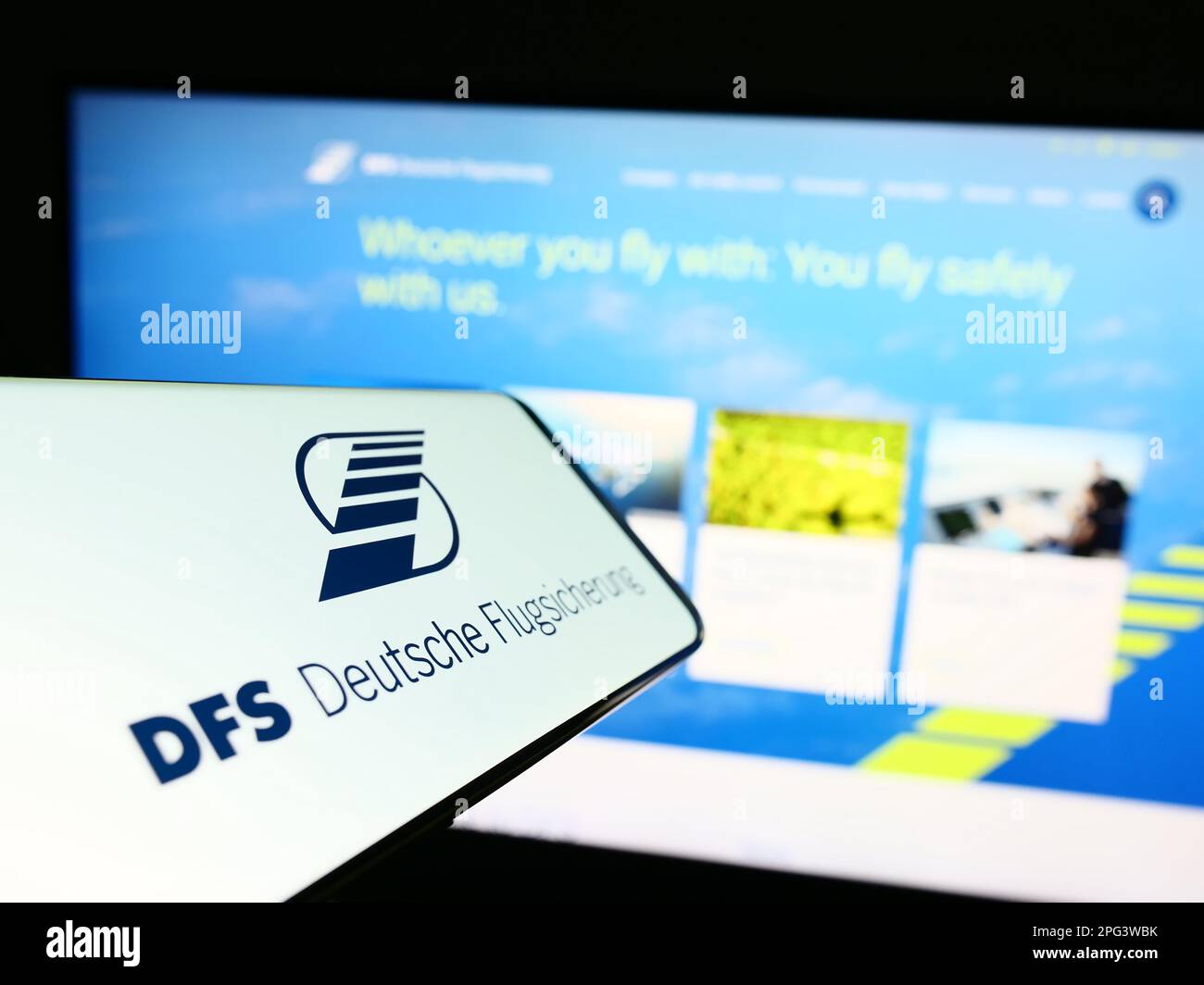 Cellulare con logo di controllo del traffico aereo DFS Deutsche Flugsicherung sullo schermo di fronte al sito web. Messa a fuoco al centro a destra del display del telefono. Foto Stock