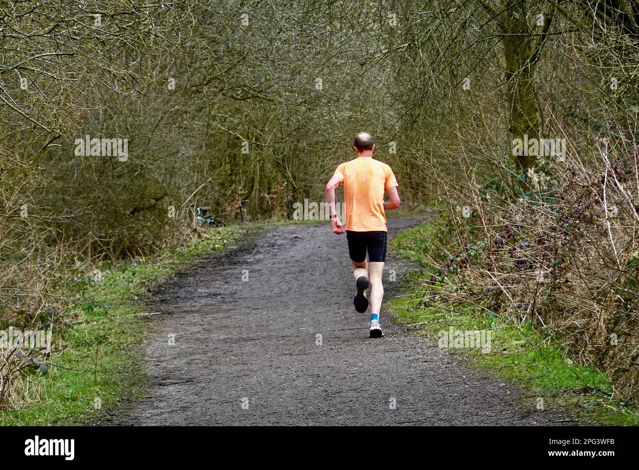 Un uomo corre lungo il Sentiero della Sett Valley, Derbyshire Foto Stock
