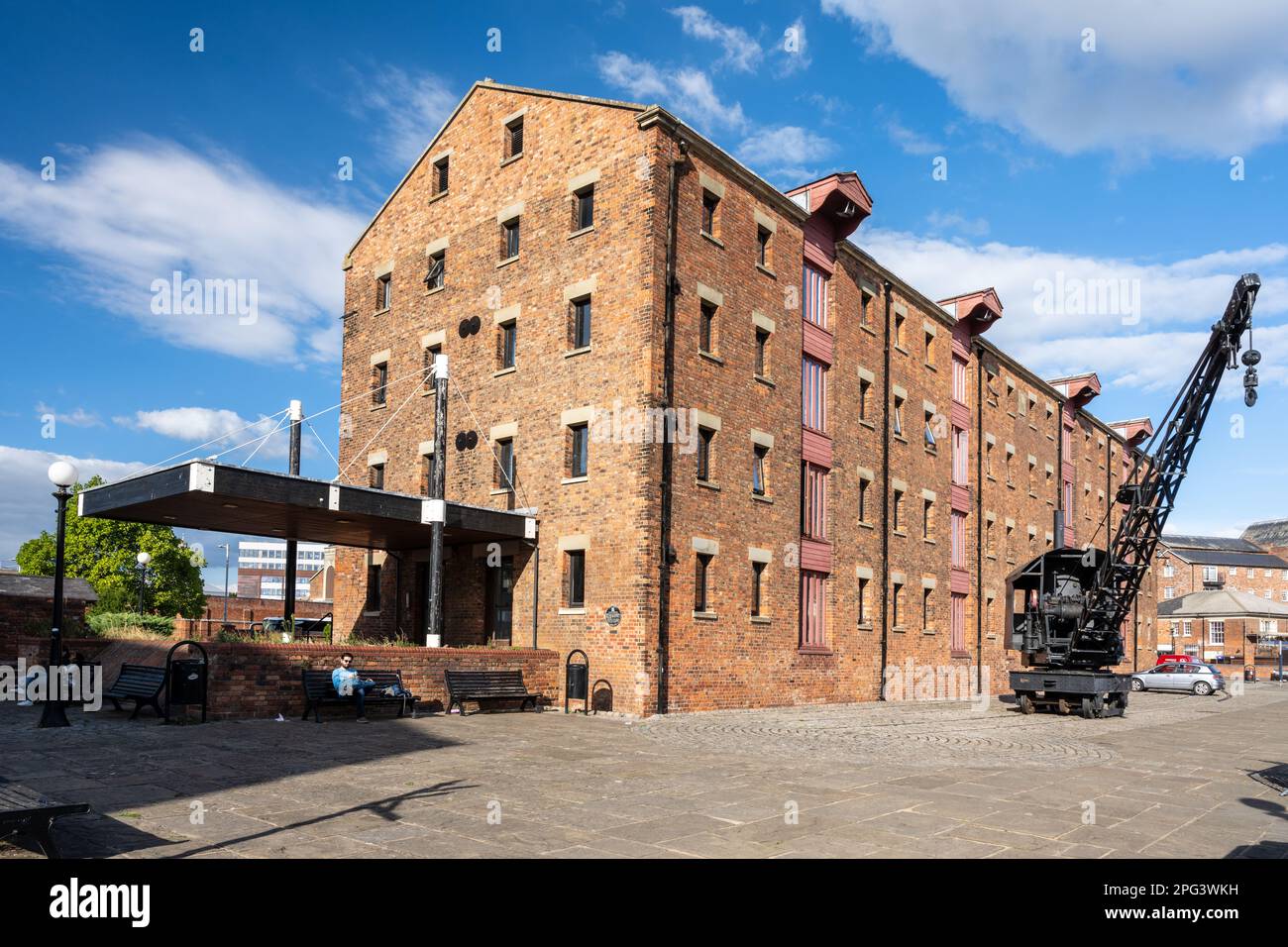 Una vecchia gru a vapore su rotaia si trova all'esterno di un edificio adibito a magazzino sul molo rigenerato di Gloucester Docks. Foto Stock