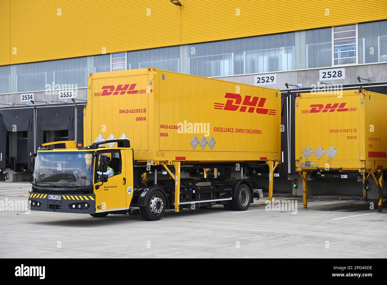 Deutsche Post DHL ha messo in funzione la più grande sede di spedizione di pacchi della Germania il 20 marzo 2023. Lavorazione fino a 72.000 pacchi all'ora nel centro pacchi Aschheim II vicino a Monaco. Un veicolo di conversione trasporta un cassone di scambio, un contenitore di trasporto, un contenitore, un contenitore di trasporto? Foto Stock