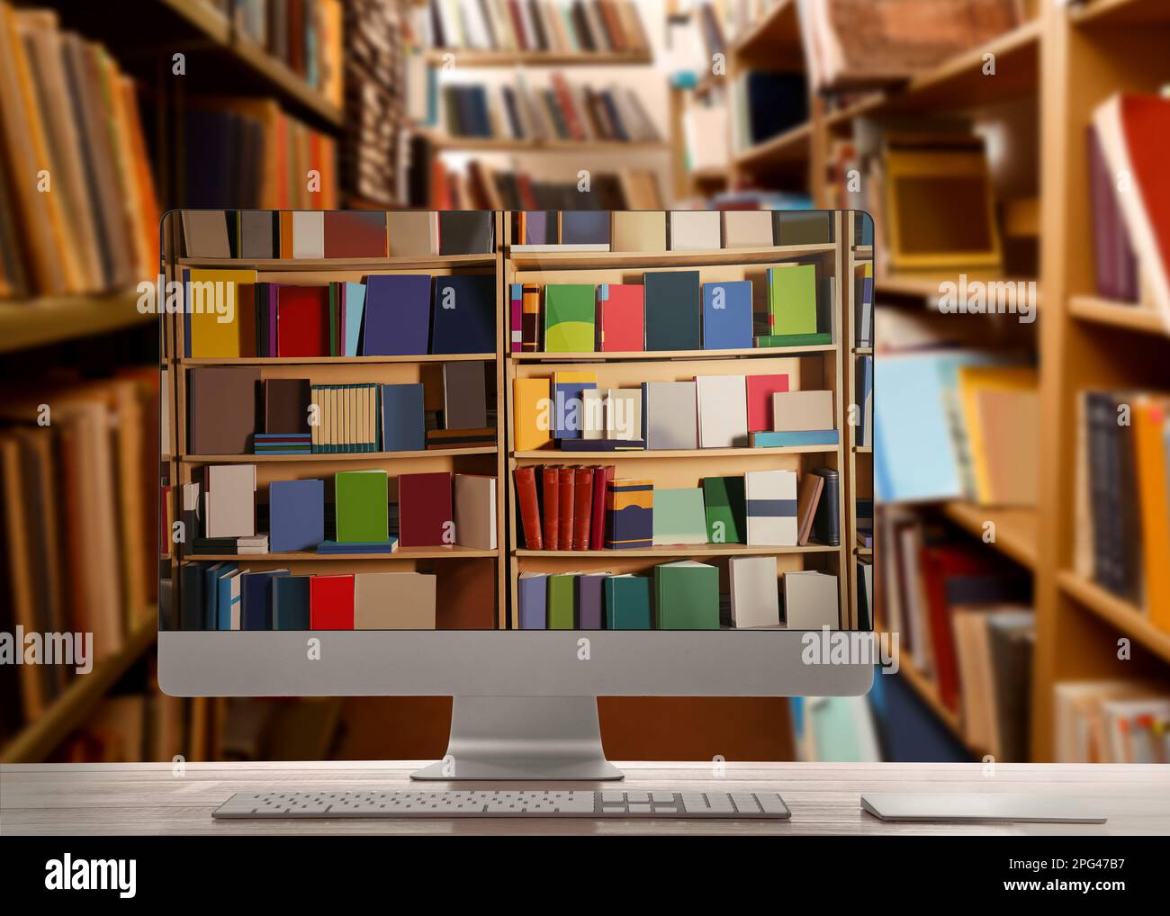 Biblioteca online. Computer moderno su tavolo di legno e scaffali con libri al coperto Foto Stock