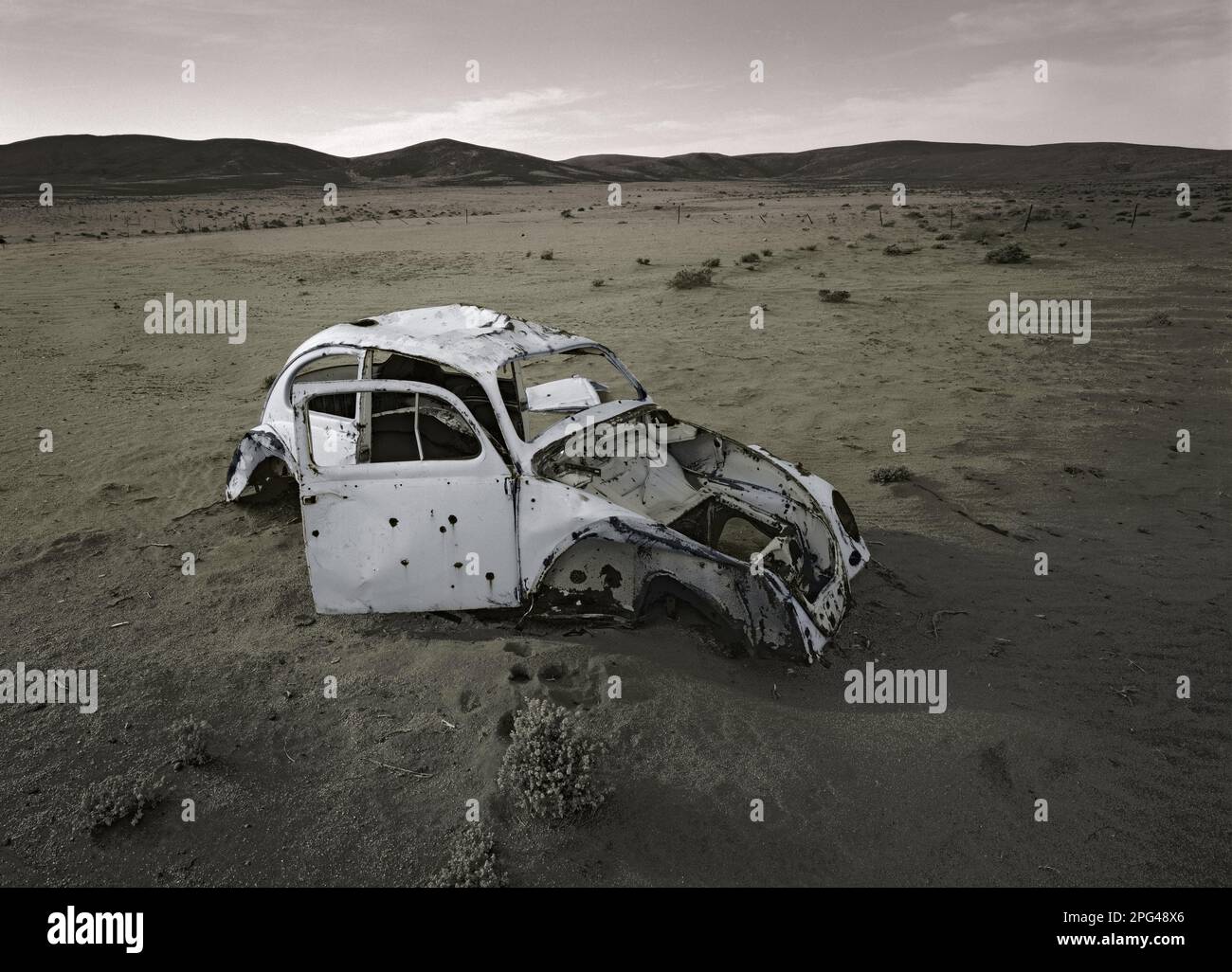 Un vecchio Beatle Volkswagen si trova nel deserto del Namib sulla strada C13 tra le città di Aus e Witpütz a est dell'altopiano Huib-Hoch in Namibia. Foto Stock