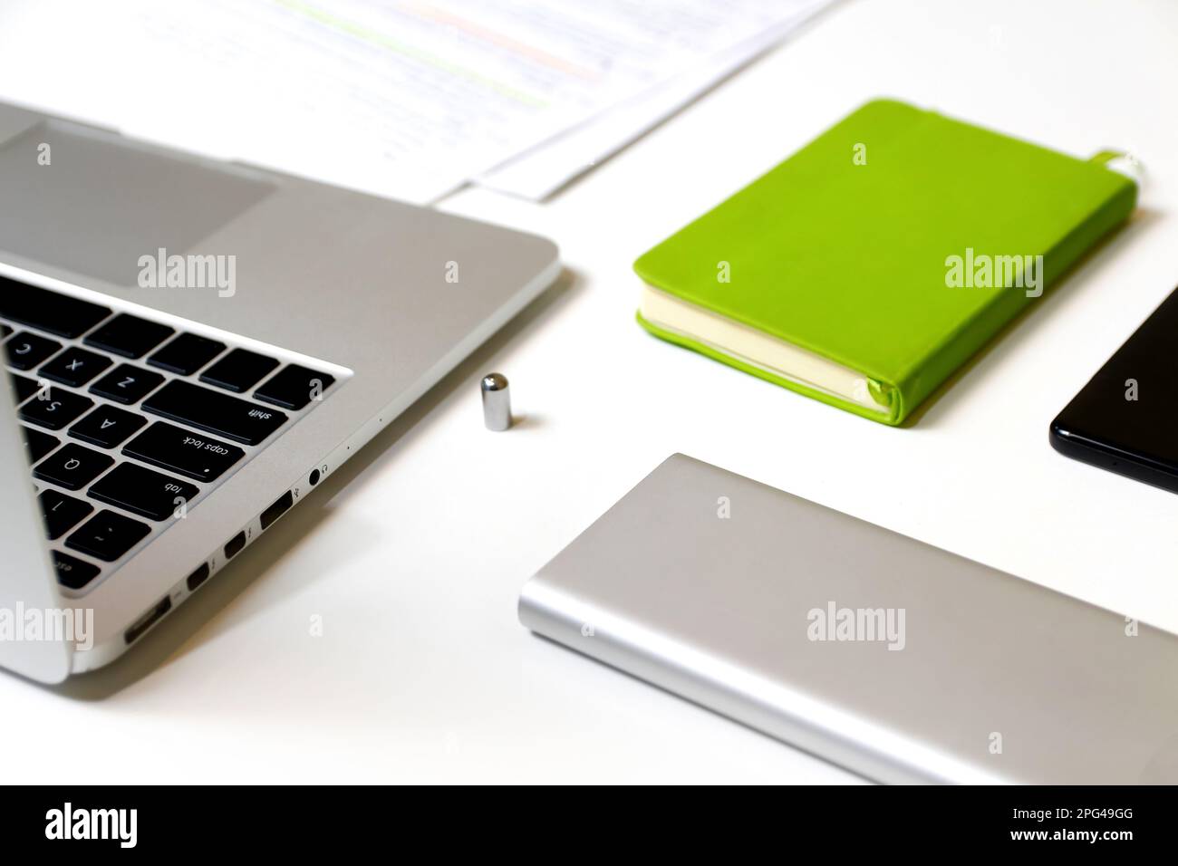 Ambiente di lavoro bianco. Elegante spazio di lavoro con computer portatile, forniture per ufficio, notebook ecologico in ufficio. Concetto di scrivania. Fuori fuoco. Foto Stock