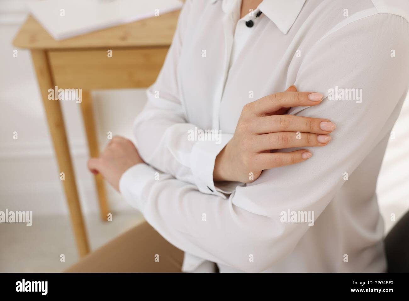 Donna a contatto camicia in tessuto bianco liscio per interni, primo piano Foto Stock