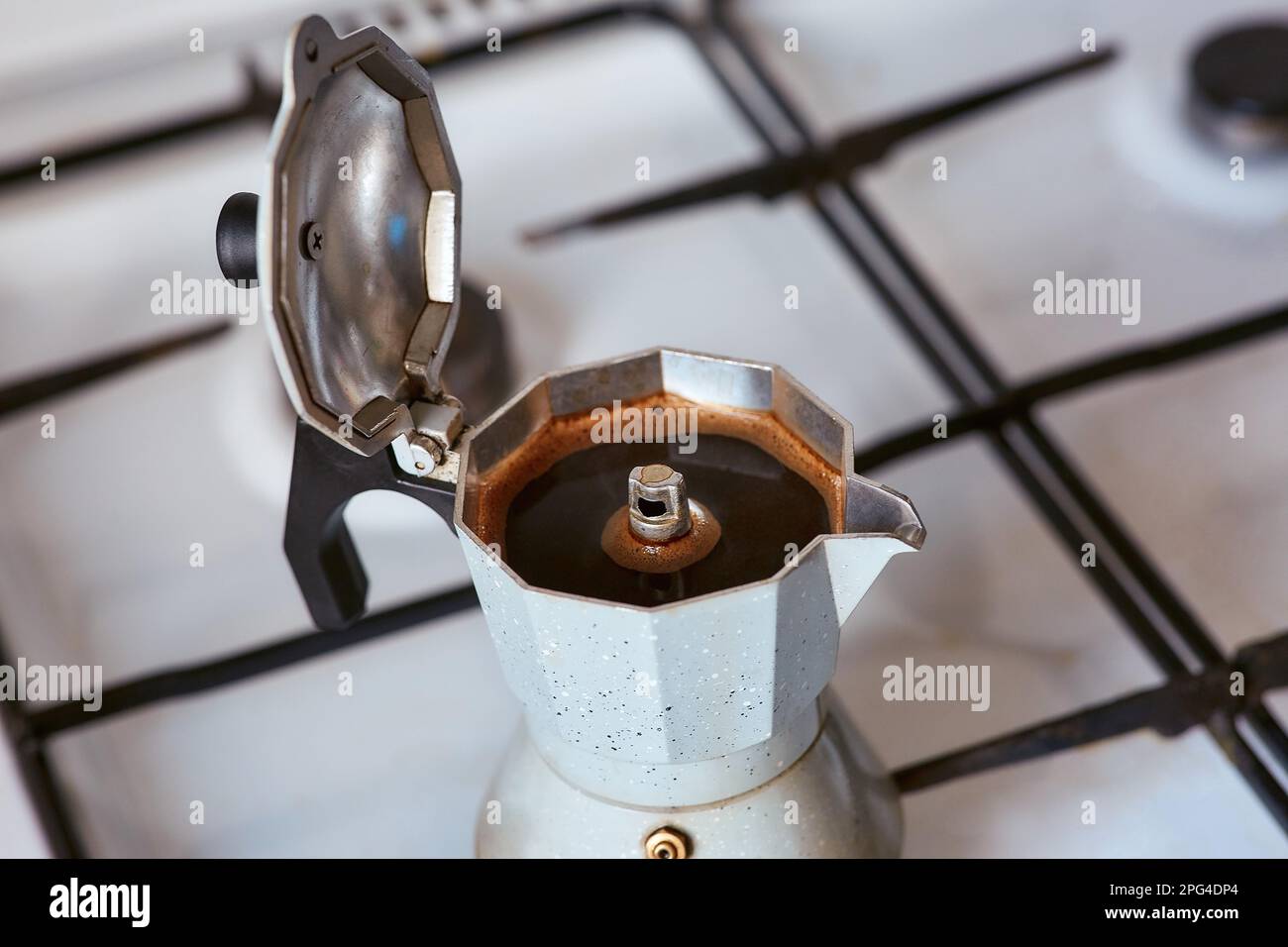 Una macchina per il caffè geyser su una stufa a gas produce una porzione di caffè Foto Stock