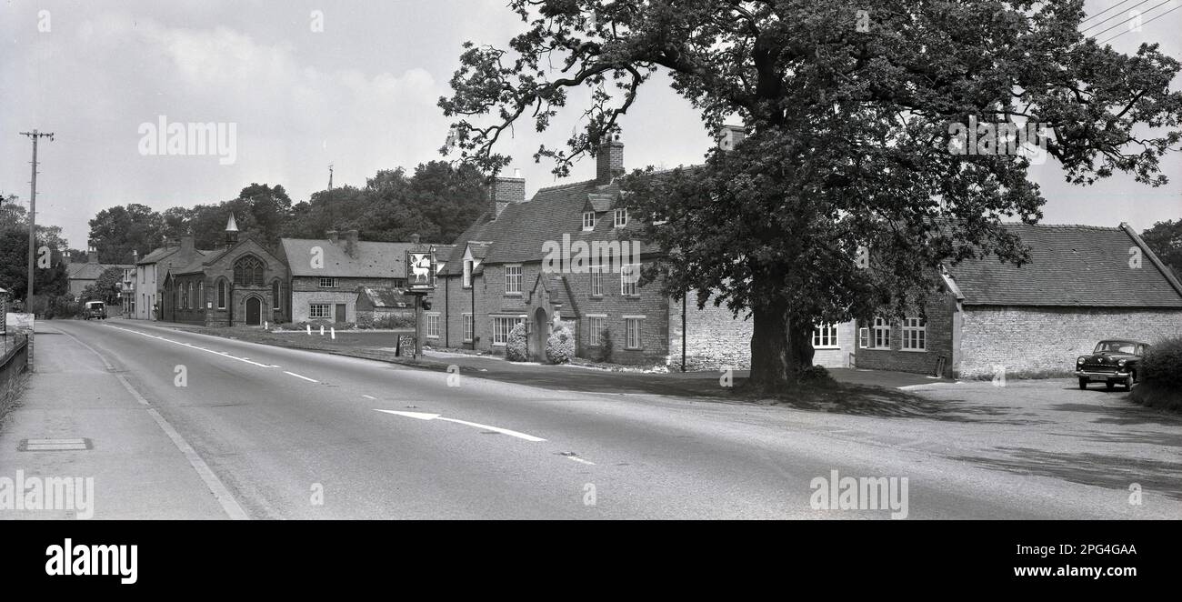 Anni '1950, storica, vista esterna di una grande strada con una casa pubblica, il White Hart situato accanto ad essa, Inghilterra, Regno Unito. Foto Stock