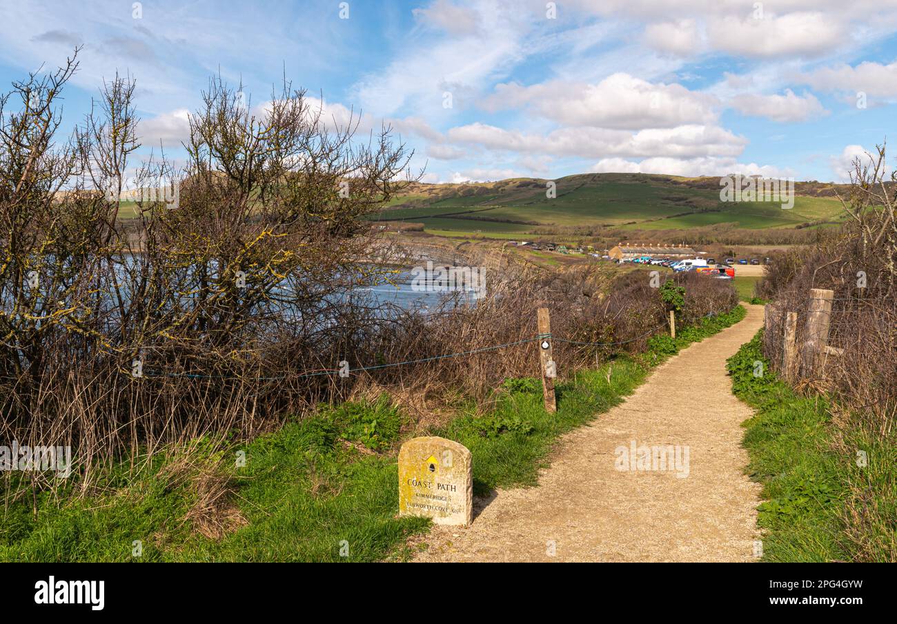 Sentiero in ghiaia che conduce al parcheggio di Kimmeridge Bay con un pennarello in pietra che mostra la distanza da Lulworth Cove sul sentiero della costa sud-occidentale Foto Stock