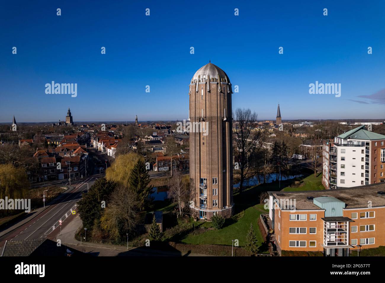 Olandese mattone acqua torre vista aerea in Zutphen ora riproposto come una casa residenziale con la città anseatica sullo sfondo contro un cielo blu. Foto Stock