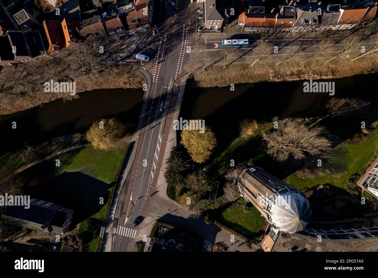 Ponte sul canale in cima all'aereo urbano con incrocio accanto all'ex torre d'acqua olandese in mattoni a Zutphen ora riproposta come una casa residenziale. Foto Stock