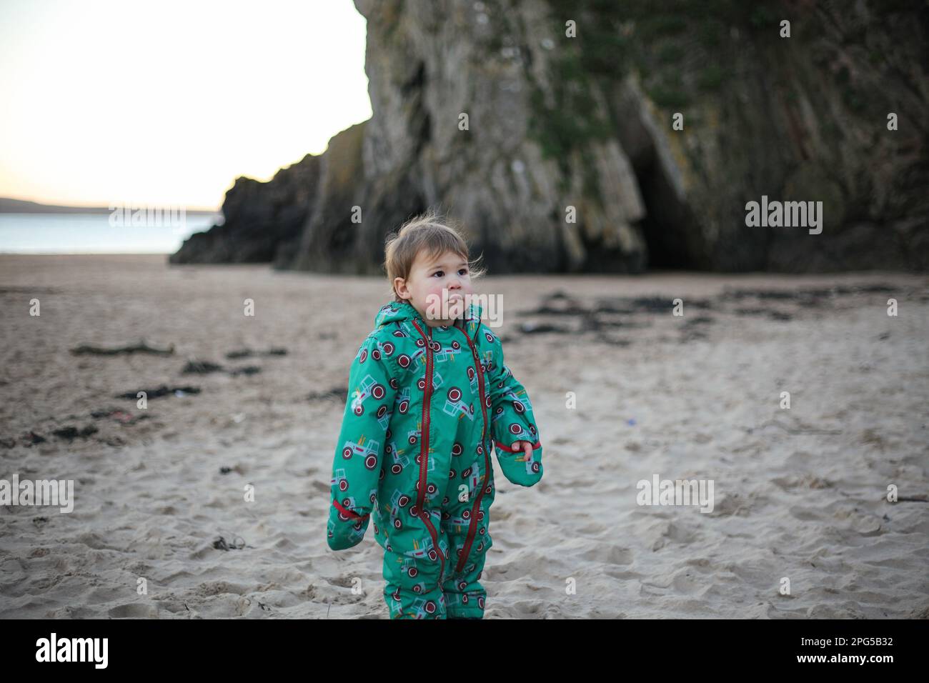 Bimbo in spiaggia in inverno a Tenby Foto Stock