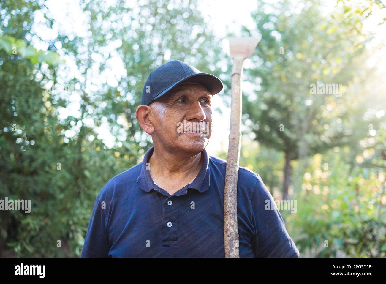 Ritratto di un contadino mapuche indigeno anziano che tiene un raschietto da giardino in campagna Foto Stock