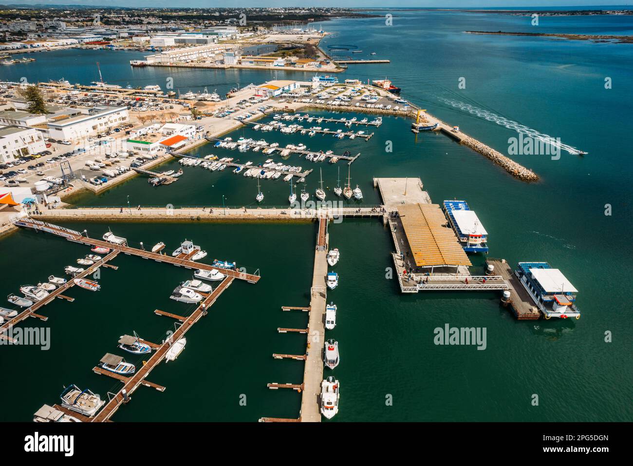 Vista aerea del drone di turisti presso un molo di molo che parte da un traghetto sulla Ria Formosa, regione dell'Algarve, Portogallo Foto Stock