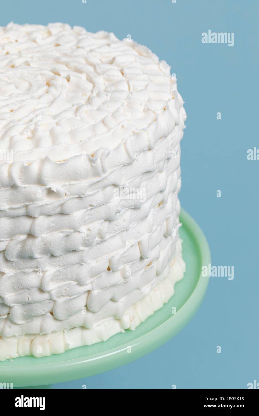 Torta a strati decorata in modo ornato con glassa bianca Foto Stock