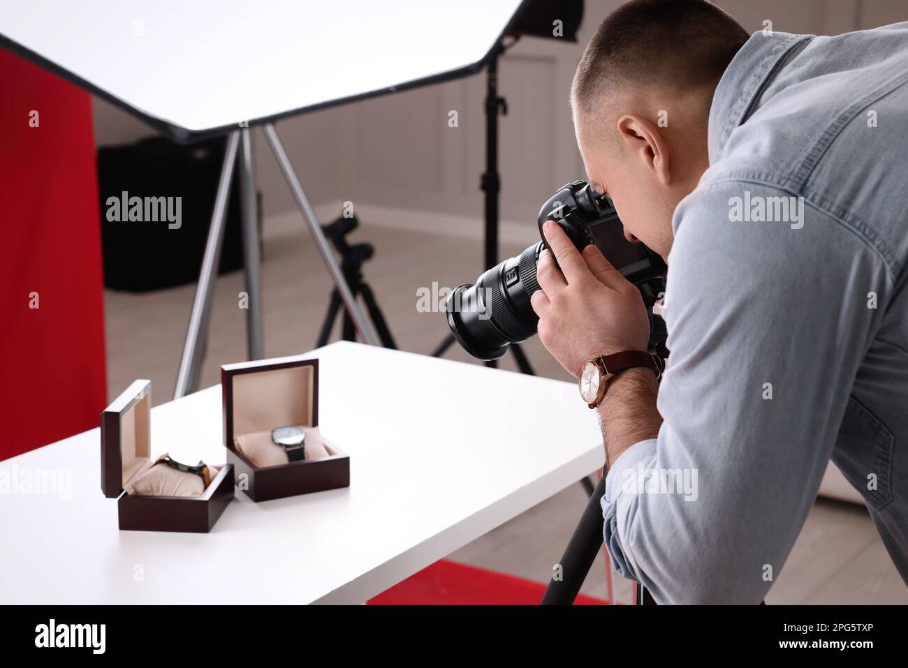 Fotografo professionista che fotografa i costosi orologi da polso in studio Foto Stock