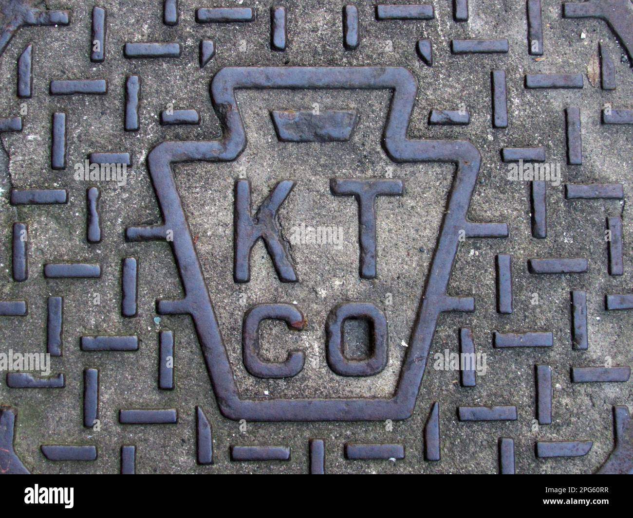 Il logo dell'ex Keystone Telephone Company spicca su una copertina di un condotto a Philadelphia. Foto Stock