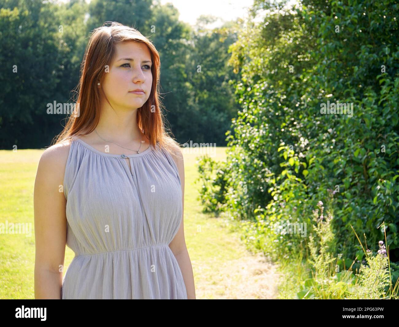 Giovane donna che indossa abiti estivi in un parco Foto Stock