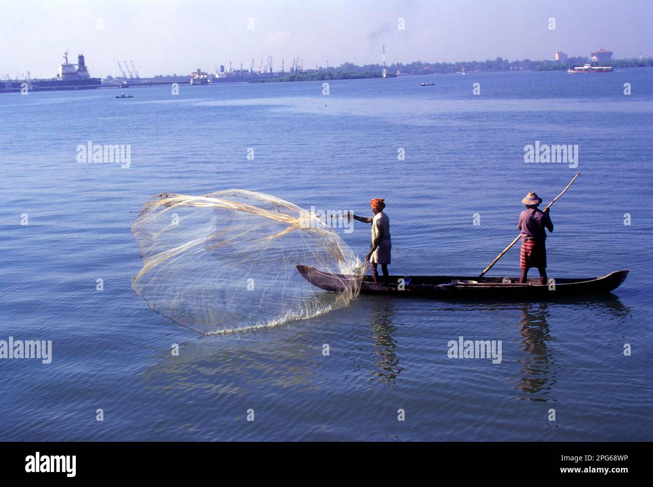 Un pescatore che pesca gettando la sua rete, backwaters di Kochi o Cochin, Kerala, India, Asia Foto Stock