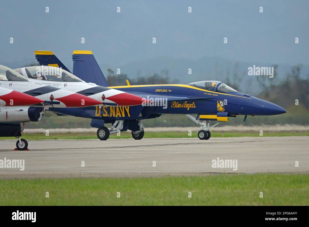 Point Mugu, California / USA - 18 marzo 2023: Un USA Navy Blue Angels team di dimostrazione volo F-18 jet taxi oltre una fila di Air Force Thunderbirds. Foto Stock
