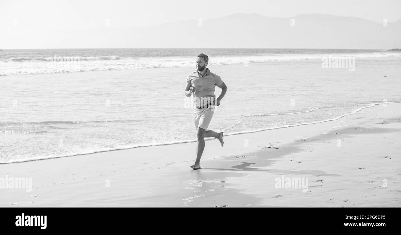 uomo sano che corre sulla spiaggia. estate energica. runner sentire la libertà. godersi la mattina. Foto Stock