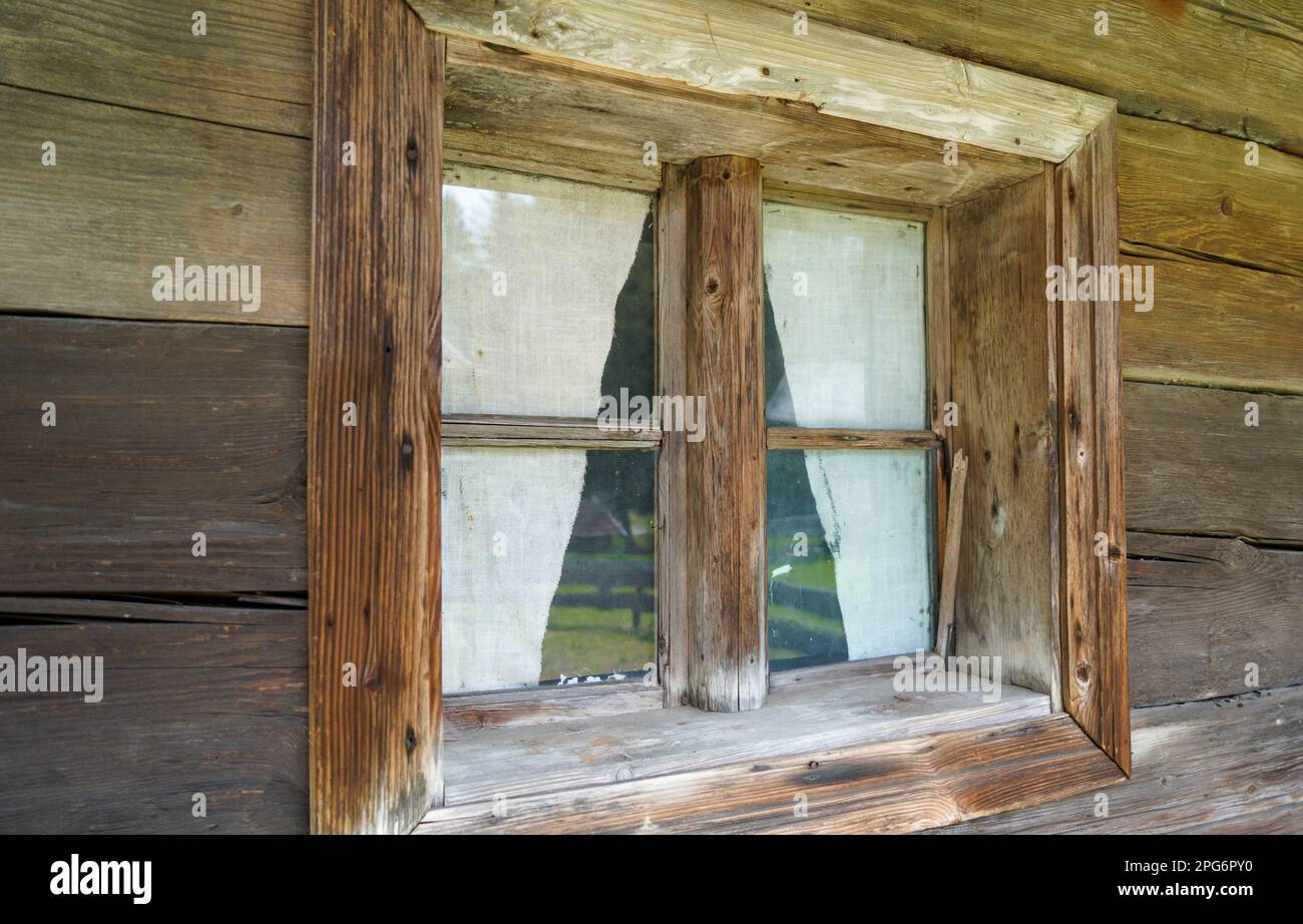 Finestra in legno invecchiata con vetri e parzialmente intemperie in case rustiche Foto Stock