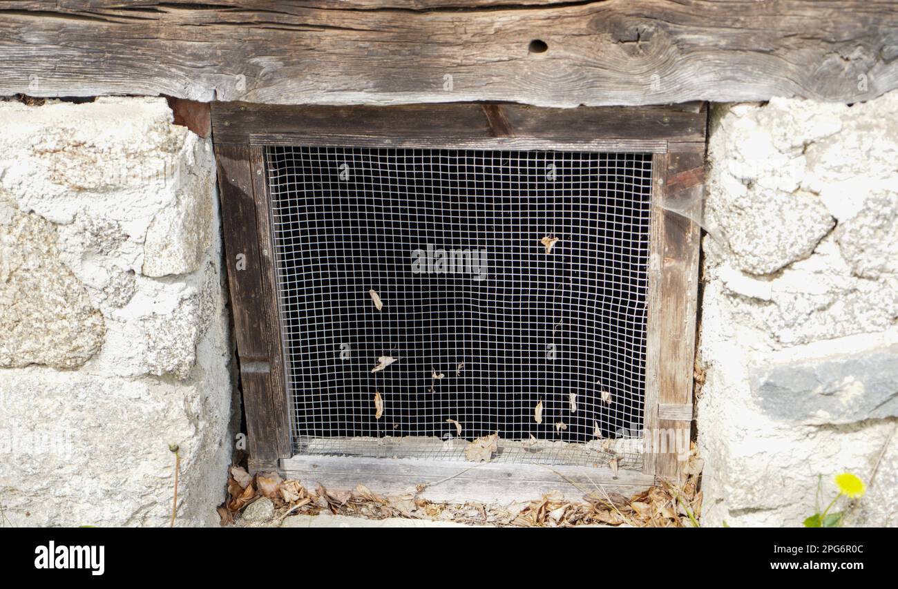 Finestra in legno invecchiata con vetri e parzialmente intemperie in case rustiche Foto Stock