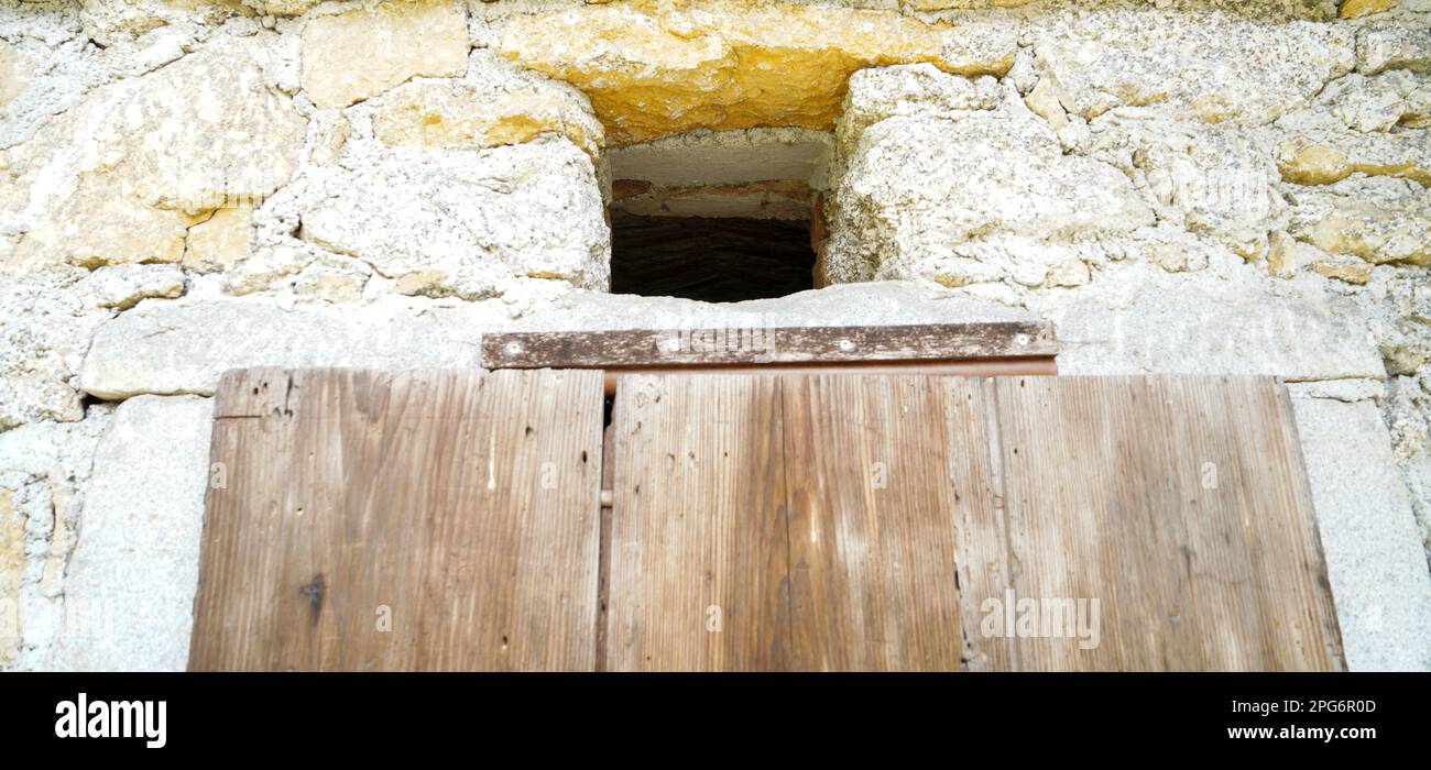 Finestra in legno invecchiata con vetri e parzialmente intemperie in case rustiche Foto Stock