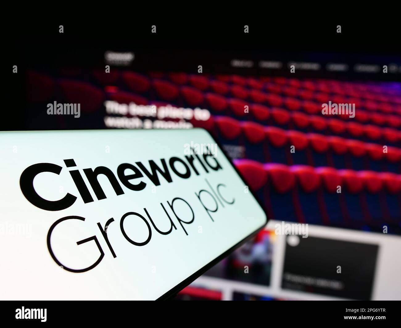 Cellulare con logo della società cinematografica britannica Cineworld Group plc sullo schermo di fronte al sito web aziendale. Messa a fuoco a sinistra del display del telefono. Foto Stock