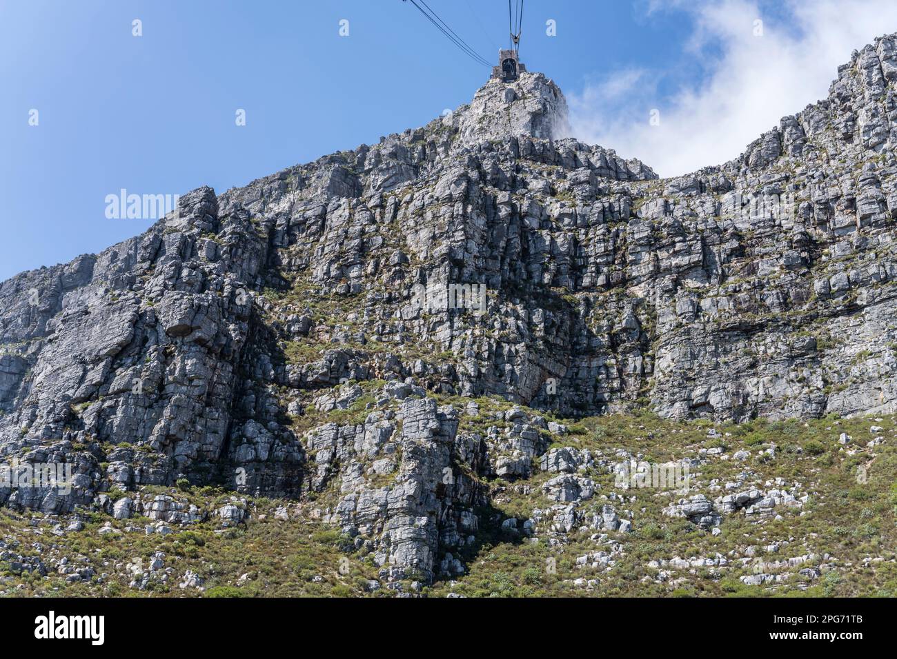Paesaggio con funivia stazione superiore su ripide scogliere rocciose sulle pendici orientali di Table Mountain, girato nella luce estiva luminosa a Città del Capo, CA occidentale Foto Stock