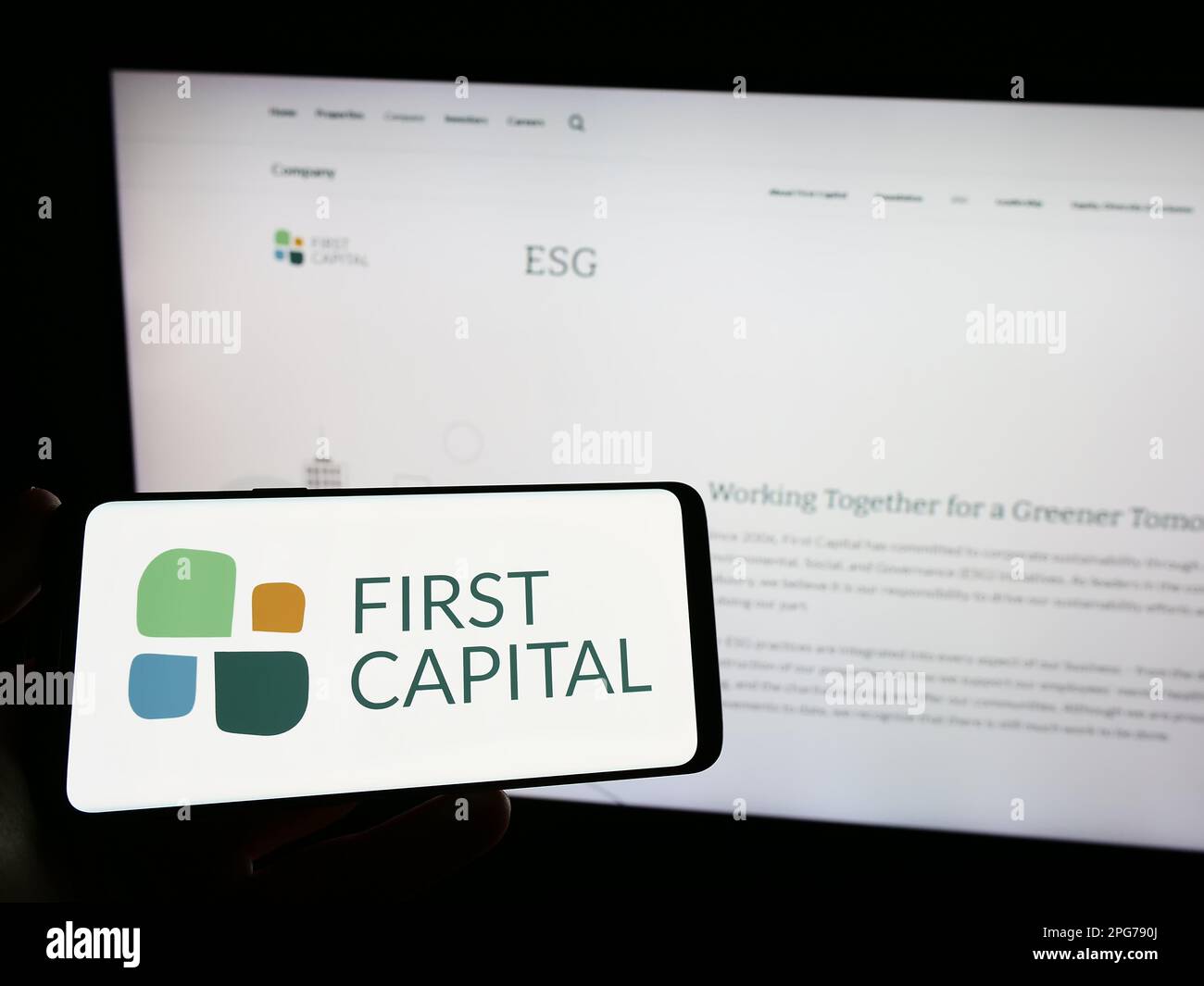 Persona che tiene lo smartphone con il logo della società immobiliare canadese First Capital REIT sullo schermo di fronte al sito Web. Messa a fuoco sul display del telefono. Foto Stock