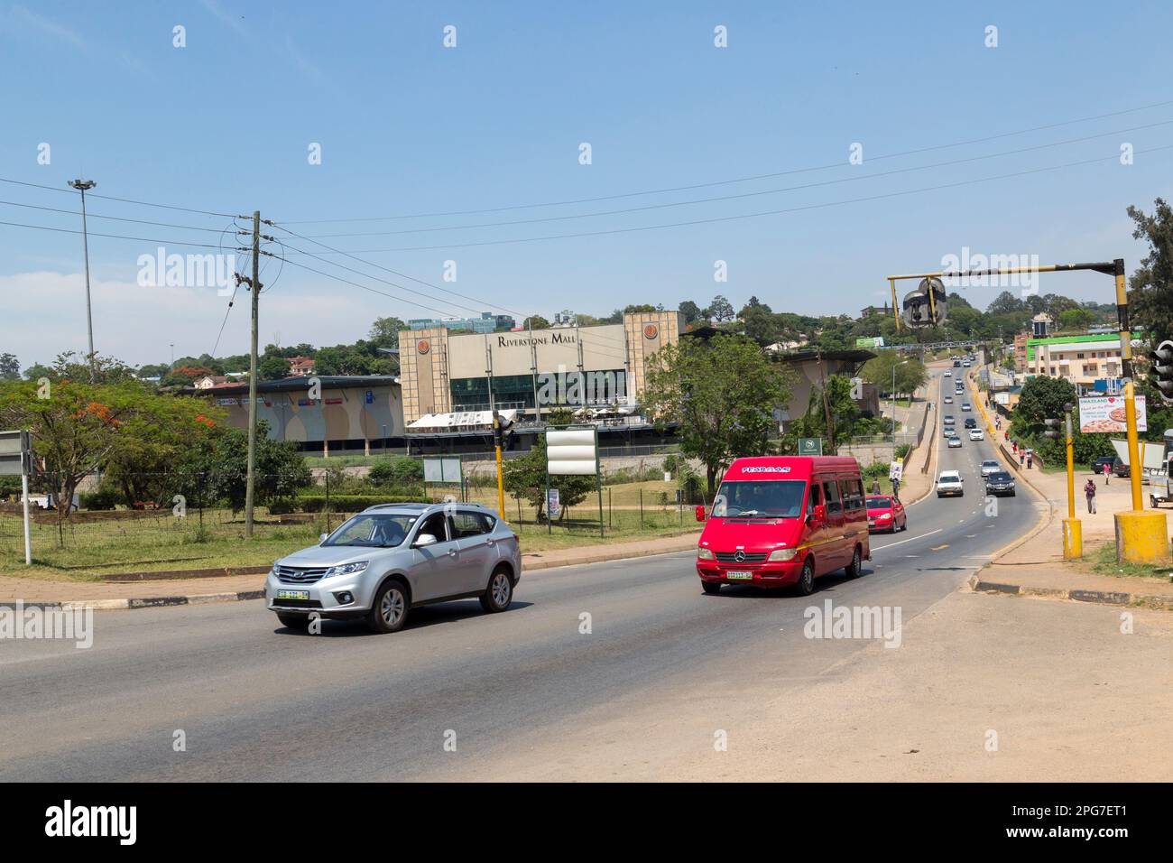 Auto che viaggiano su una strada principale nel centro di Manzini Foto Stock
