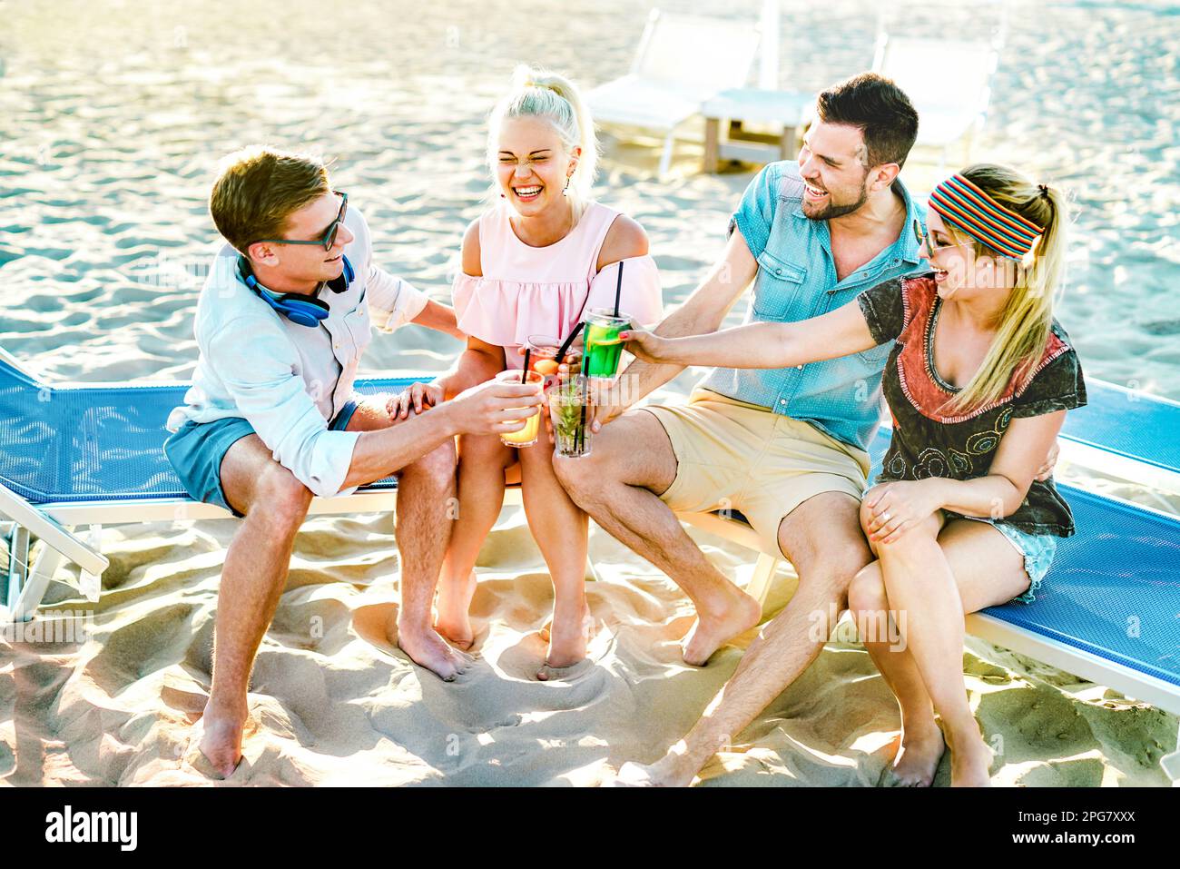 Felici amici milleniali divertirsi in spiaggia party bere cocktail al tramonto - Estate gioia stile di vita concetto con i giovani in vacanza in primavera Foto Stock