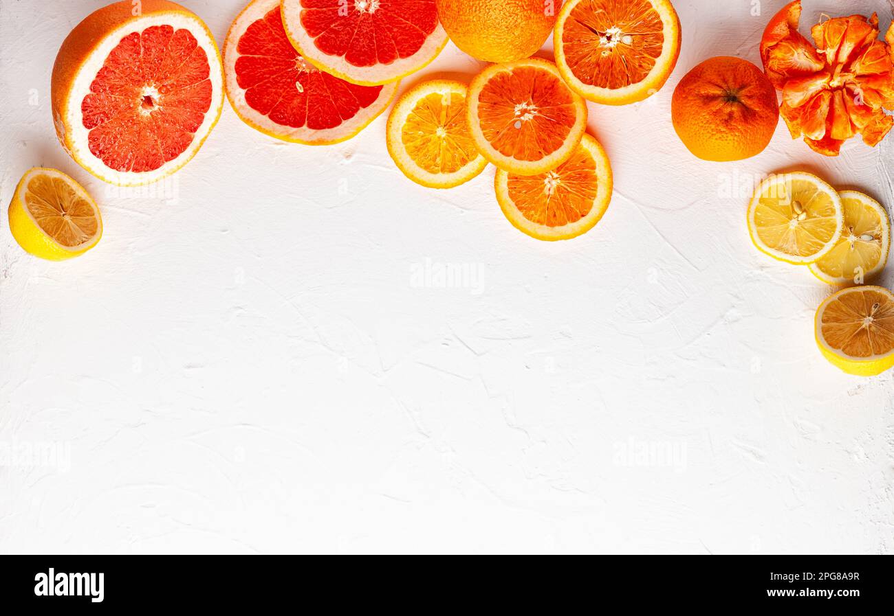 Agrumi freschi assortiti su sfondo bianco. Arance, pompelmi, limoni, mandarini. Mangiare pulito, vita sana. Vista dall'alto. Foto Stock