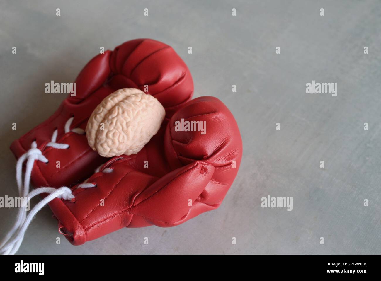 Modello di cervello umano sopra i guanti di boxe con spazio di copia. Concetto di lotta contro le malattie del cervello Foto Stock