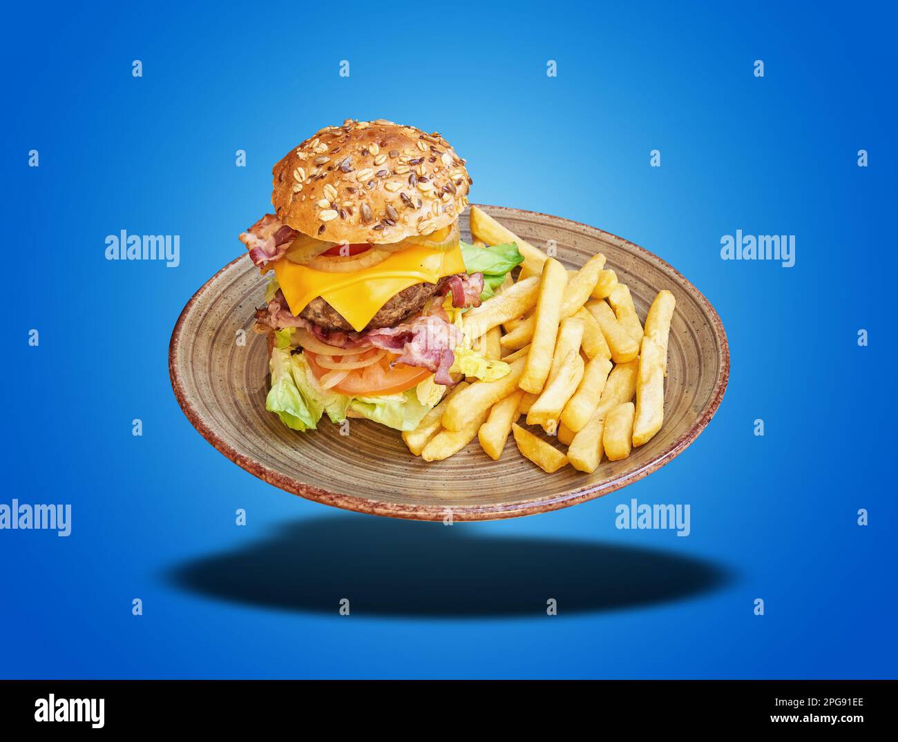 Hamburger galleggiante e patatine fritte su sfondo blu sfumato Foto Stock