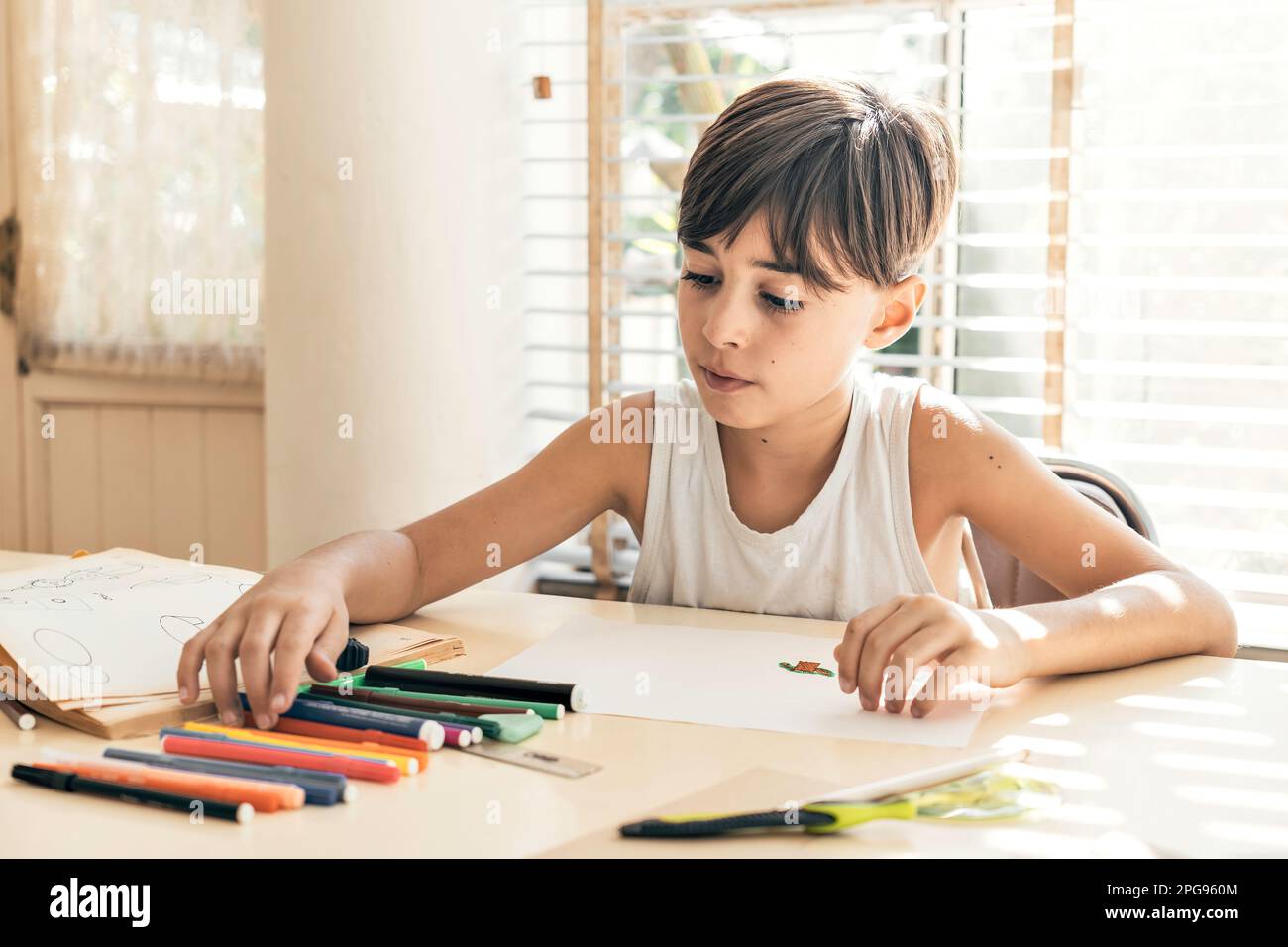 Disegno figlio in un ambiente luminoso. Un ambiente sicuro e accogliente favorisce lo sviluppo e la libera espressione dei bambini. Foto Stock