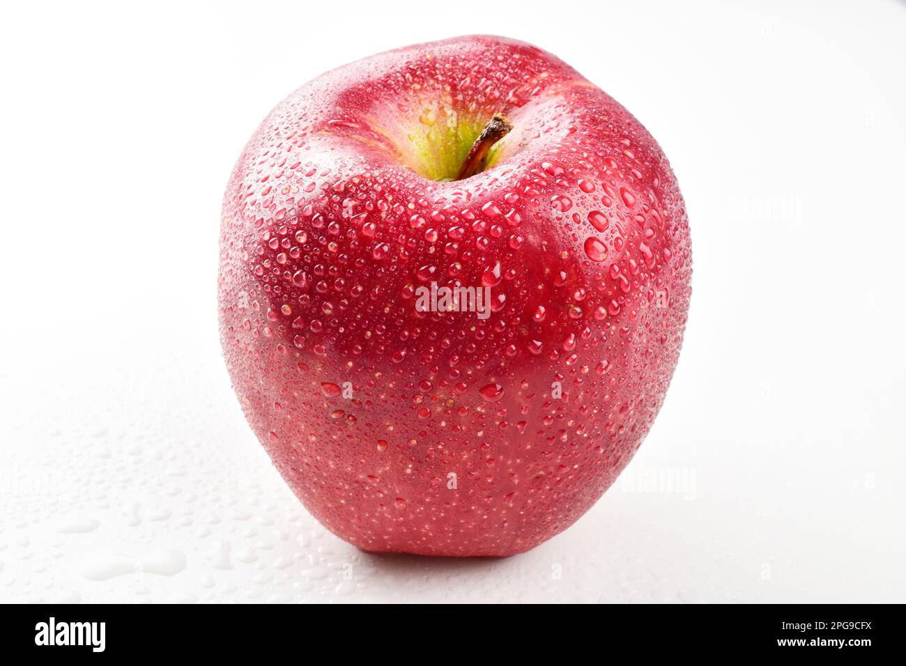 Mela rossa matura con gocce d'acqua isolate su fondo bianco, frutta fresca Foto Stock