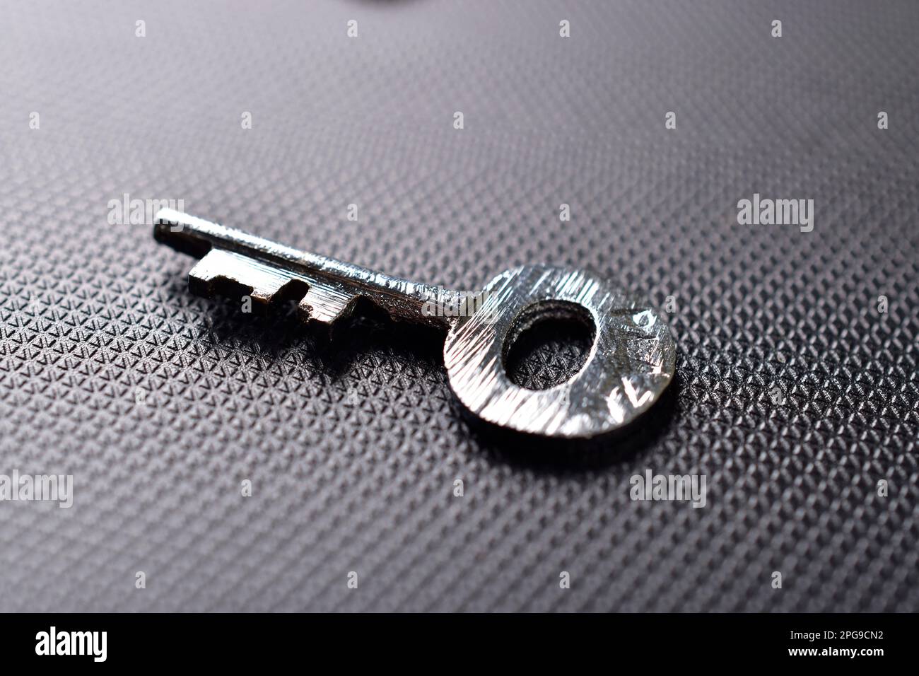 Primo piano del tasto metallico su sfondo scuro Foto Stock