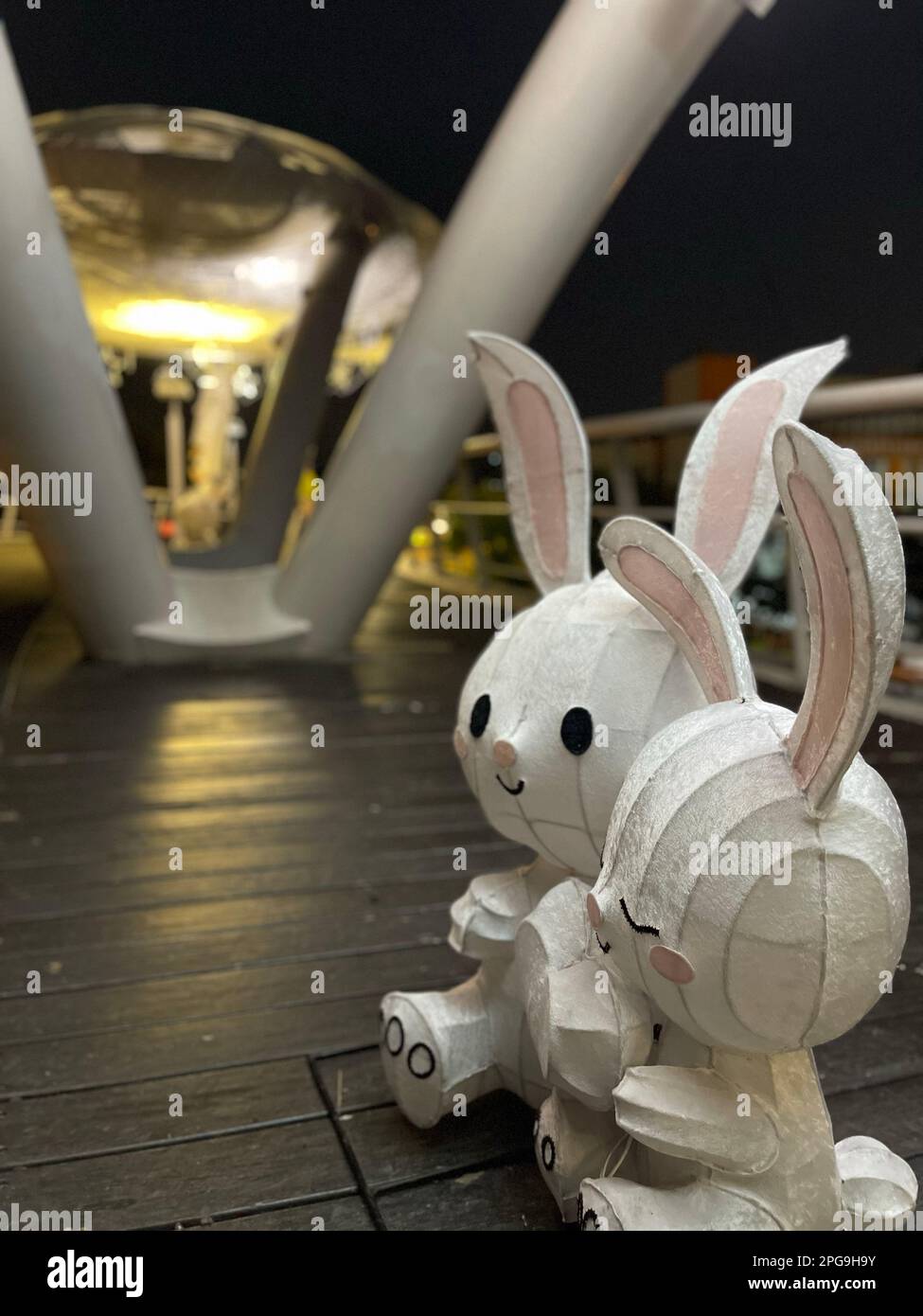 Due giocattoli di peluche bianchi, uno accanto all'altro, su un marciapiede Foto Stock