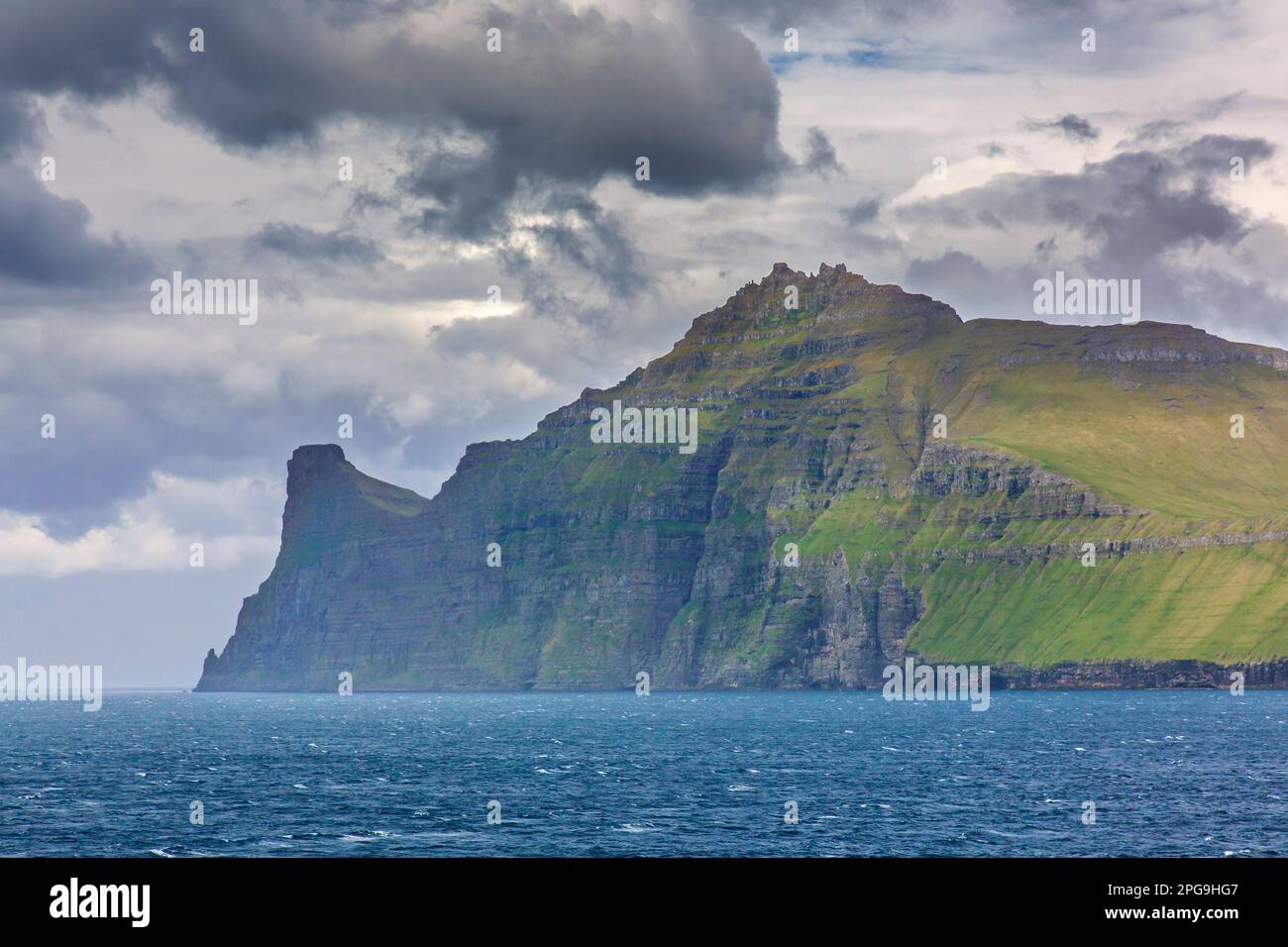 Scogliere sul mare lungo la costa frastagliata di Eysturoy / Isola Est, regione e seconda più grande delle Isole Faroe / Faroes nel Nord Atlantico Foto Stock