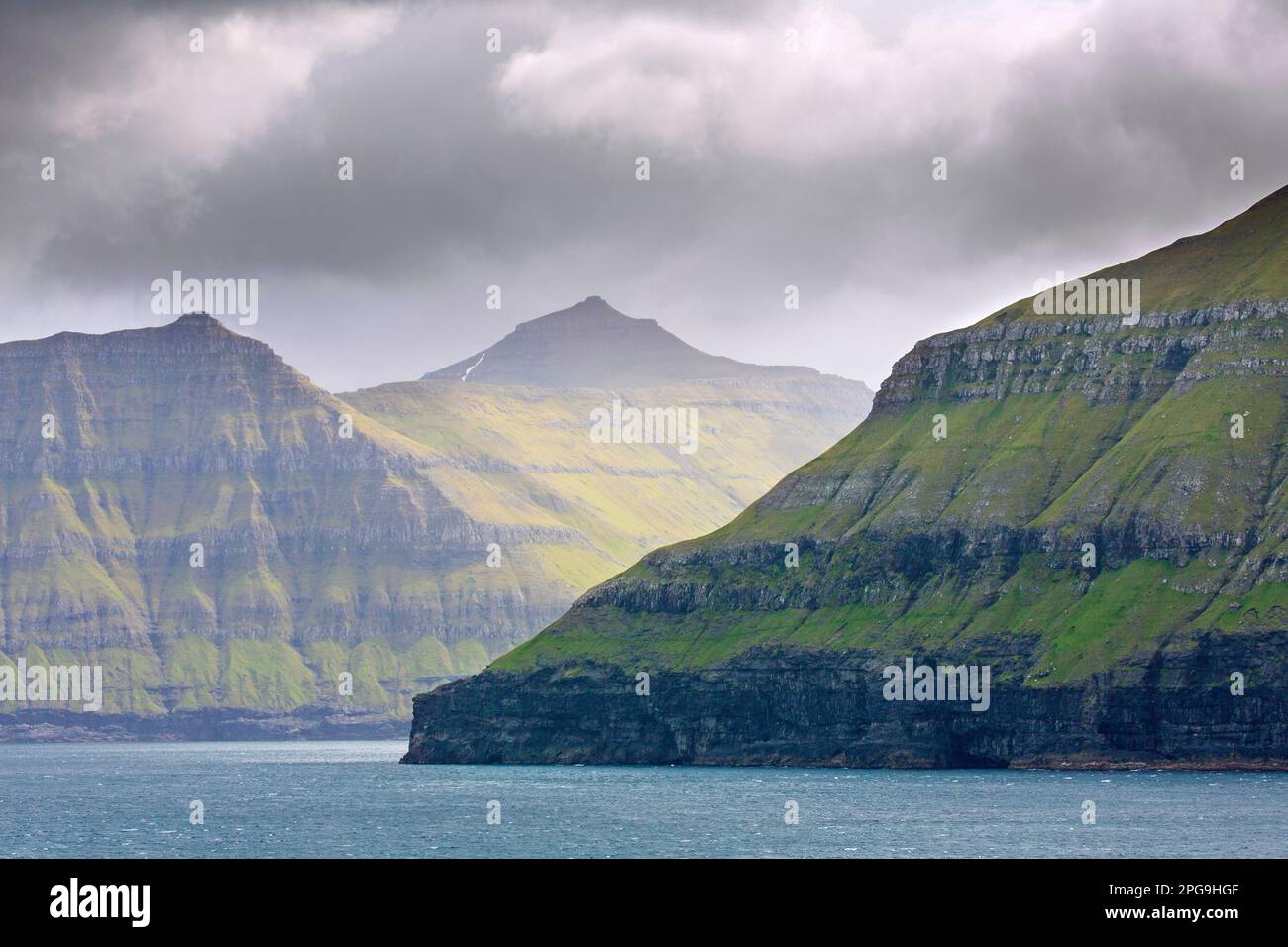 Scogliere sul mare lungo la costa frastagliata di Eysturoy / Isola Est, regione e seconda più grande delle Isole Faroe / Faroes nel Nord Atlantico Foto Stock