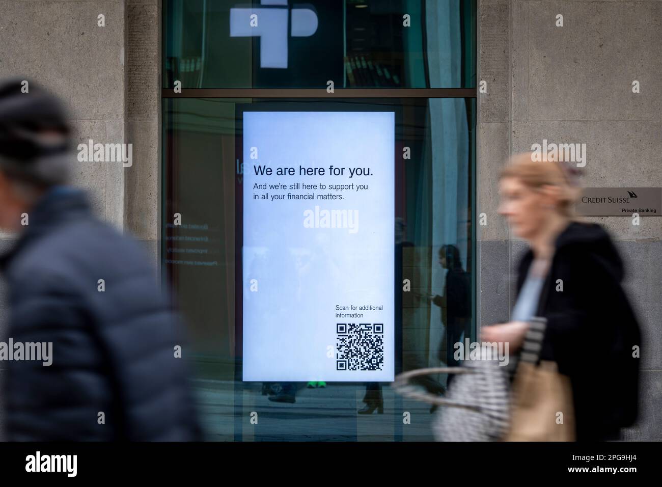 Nelle finestre della filiale principale del Credit Suisse a Ginevra viene visualizzato il messaggio " Siamo qui per voi". La banca che è stata rilevata dalla sua rivale UBS per prevenire un fallimento bancario a cascata, sta ora cercando di calmare i suoi clienti che sono preoccupati per il loro denaro. Foto Stock