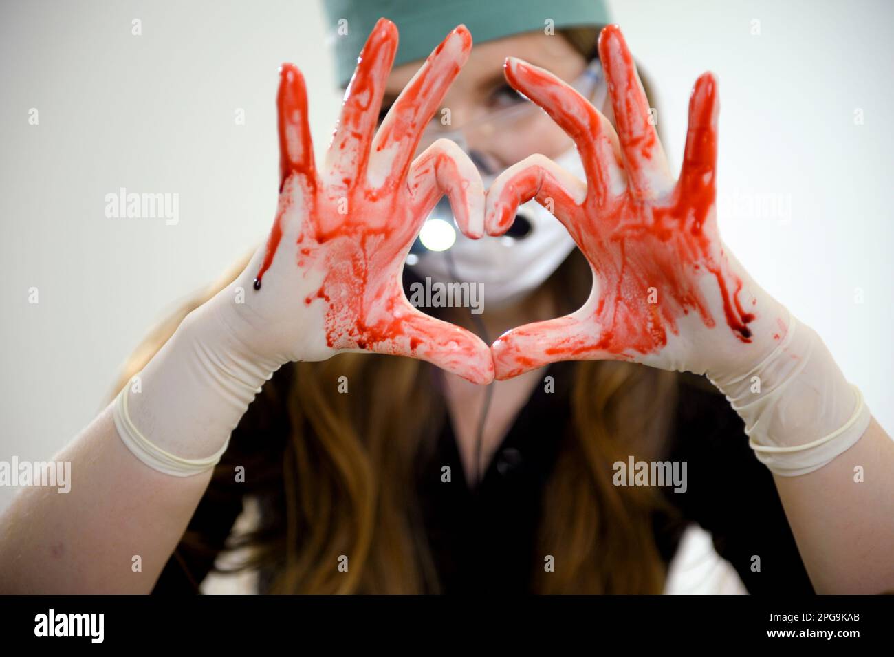 mostra con le mani cuore sulle mani flussi di sangue in trickles binocoli dentali sul naso del medico trattamento aiutare cardiologia consultare il medico in tempo Foto Stock