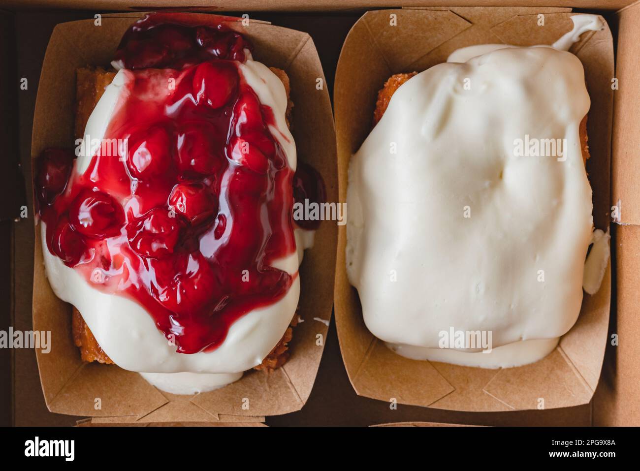 Rotolo di cannella ghiacciato alla ciliegia e rotolo di cannella di formaggio cremoso primo piano, piatto Foto Stock