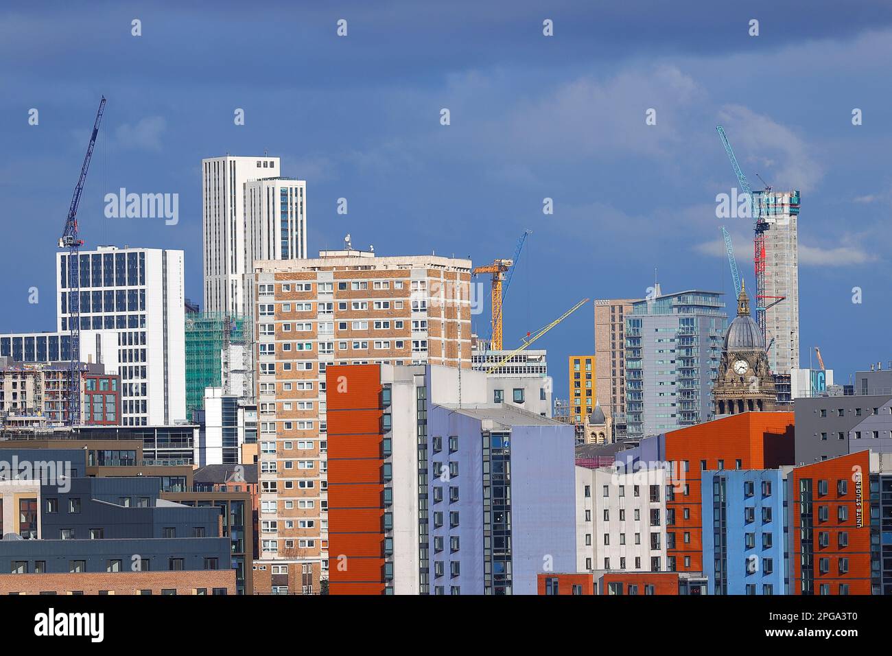 La torre dell'orologio del Municipio di Leeds è raffigurata accanto a un edificio a 31 piani in costruzione nel centro della città di Leeds Foto Stock