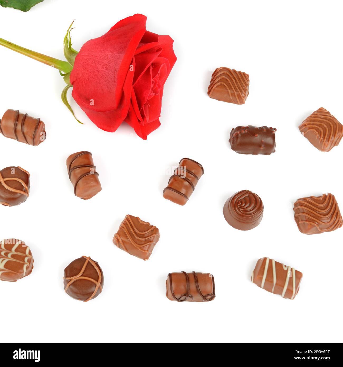 Assortimento di caramelle al cioccolato e rosa rossa isolate su sfondo bianco. Piano di giacitura, vista dall'alto Foto Stock